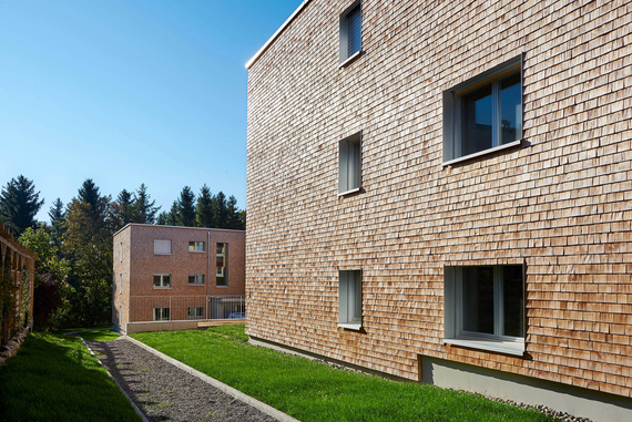 Façades de deux immeubles écologiques recouvertes de tavillons en bois